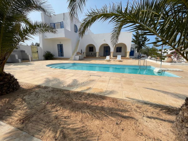 Terrasse avec piscine, véranda et barbecue.