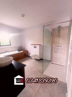 La salle de bain avec baignoire et cabine de douche