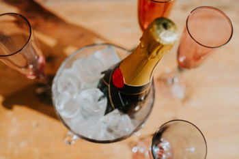 Une bouteille de champagne dans un seau avec des verres sur la table