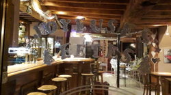 Visu sur bar en bois, tabourets, étagères en miroirs à l'arrière