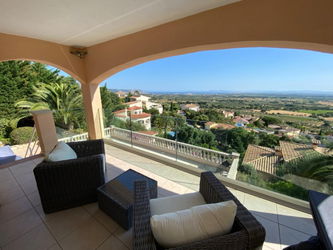 Terrasse couverte avec accès au salon et à la piscine.